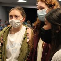Three students listen to faculty